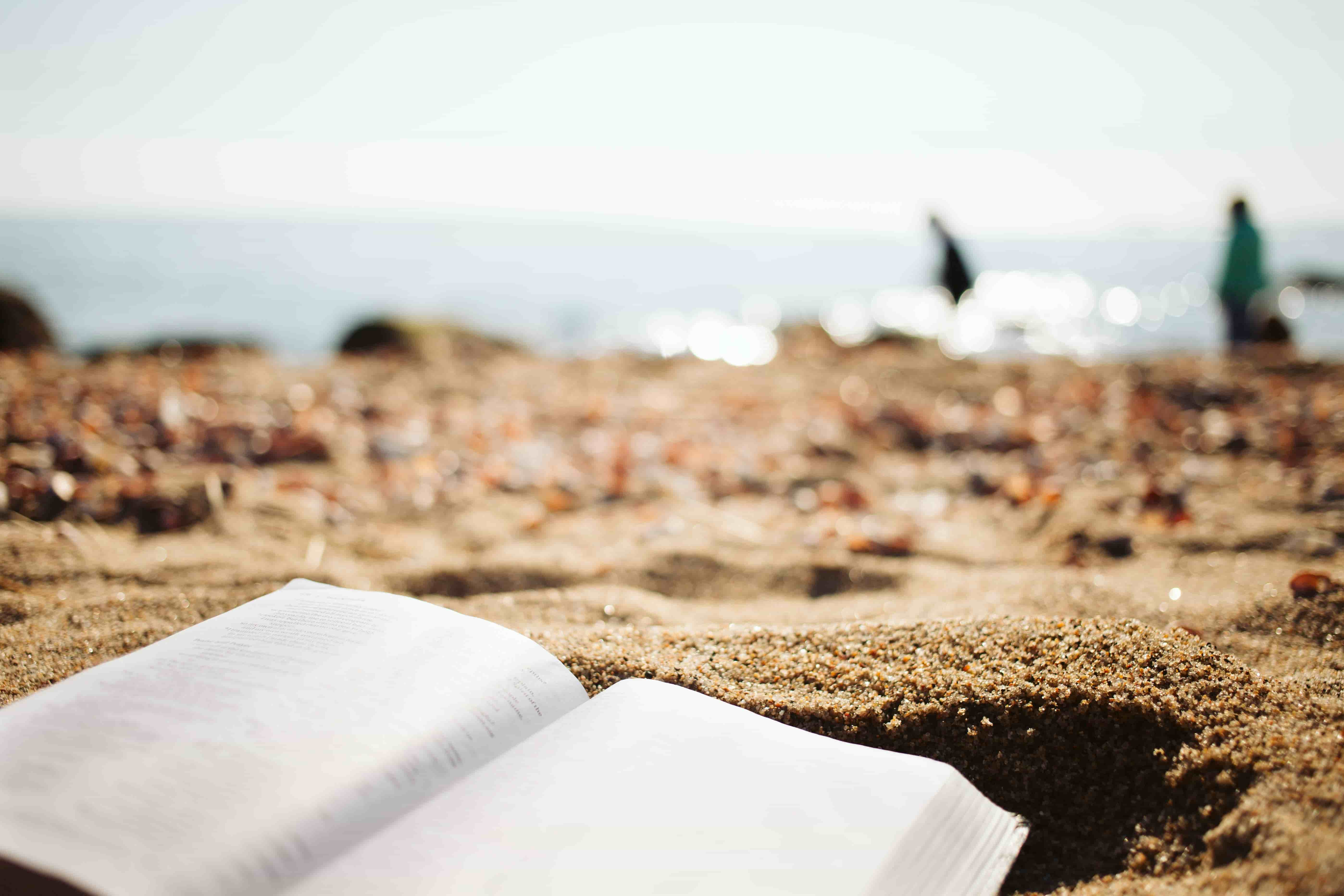 Open journal on sand by the ocean